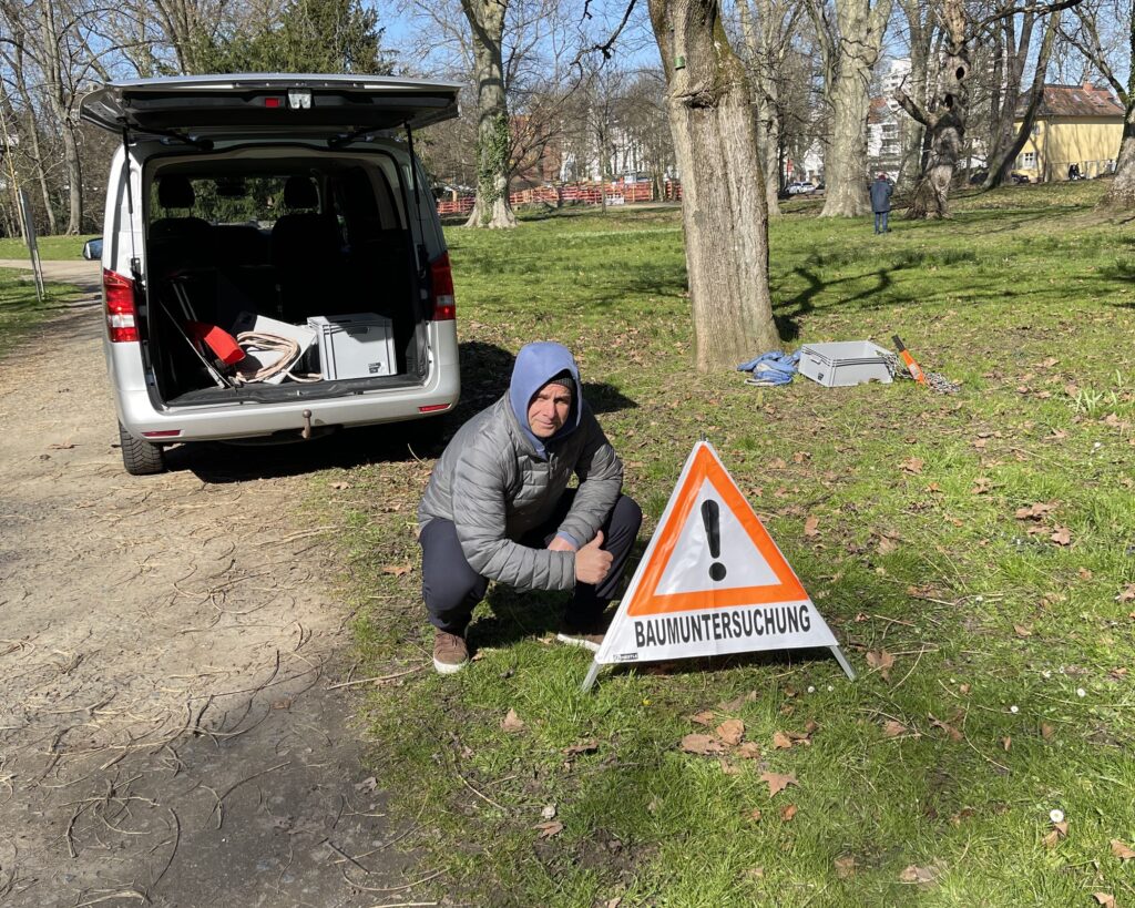 DrNektariosTreeInspection Ο Δρ. Νετάριος Παναγιώτης δίπλα σε σήμα που αναφέρει 'Baumuntersuchung' (Έλεγχος Δέντρων) κατά τη διάρκεια ελέγχου σε δέντρα στη Γερμανία.